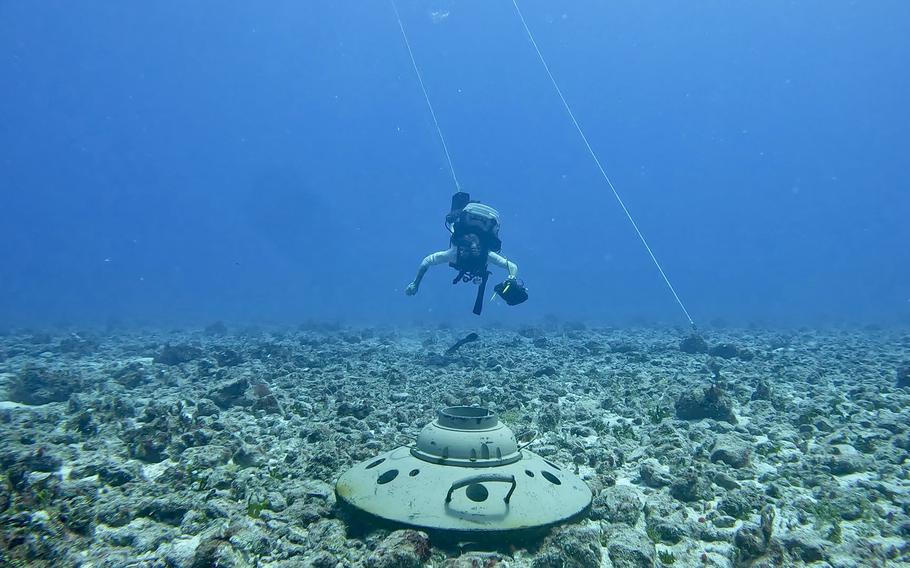 US Navy explosive ordnance disposal diver swims toward inert training mine during neutralization exercise, Hormuz mine clearance context