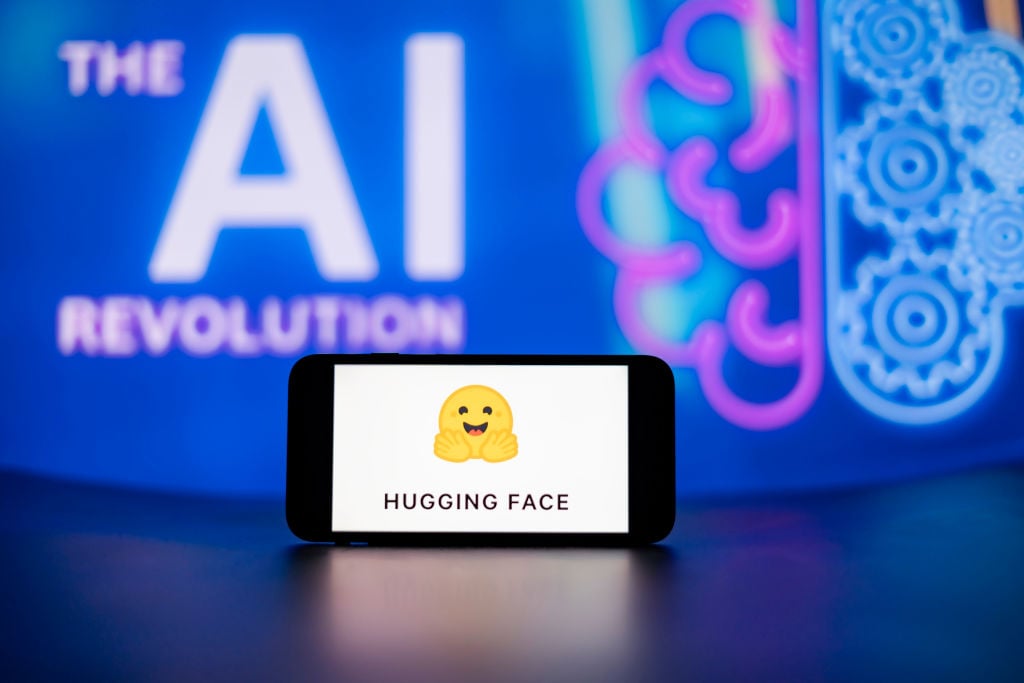 Hugging Face logo displayed on a mobile phone screen, representing the AI platform autonomously breached by OpenAI's GPT-5.6 Sol