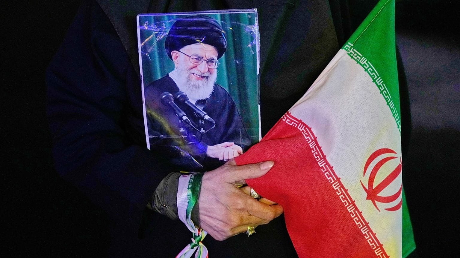 Demonstrator holds portrait of slain Supreme Leader Ali Khamenei in Tehran May 2026