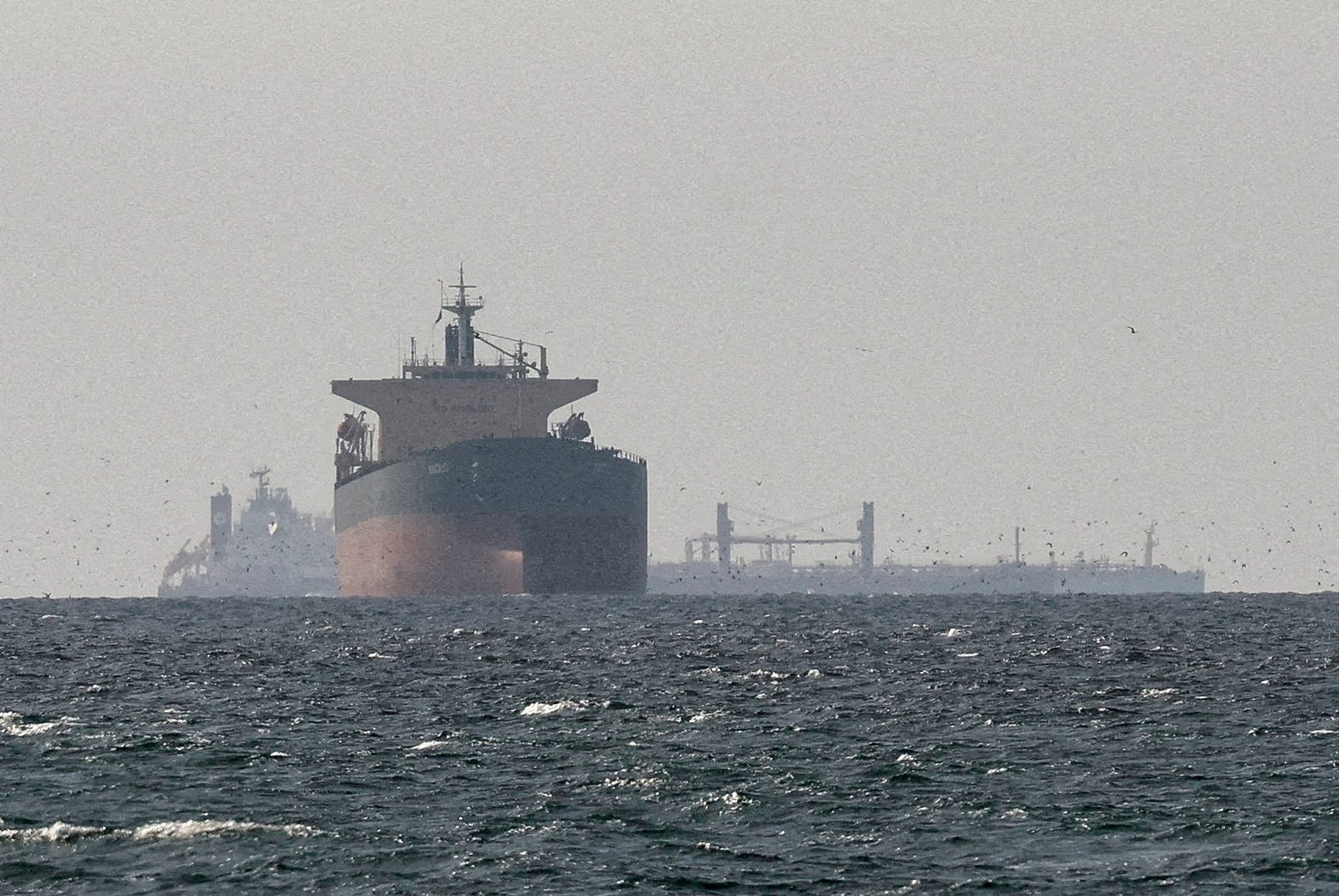 Commercial cargo vessels transiting the Arabian Gulf near the Strait of Hormuz during the 2026 conflict