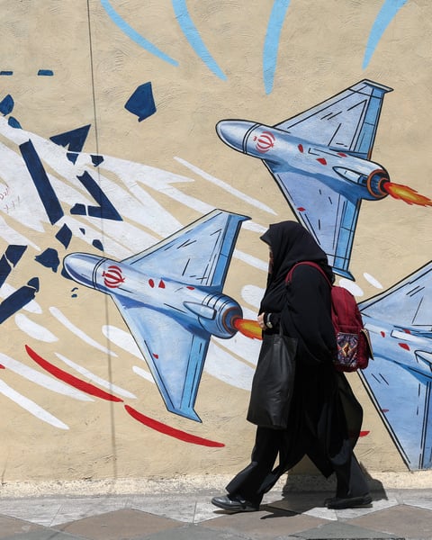 A woman walks past an anti-Israeli mural in Tehran, Iran, June 2026, during the ongoing Iran-Israel conflict