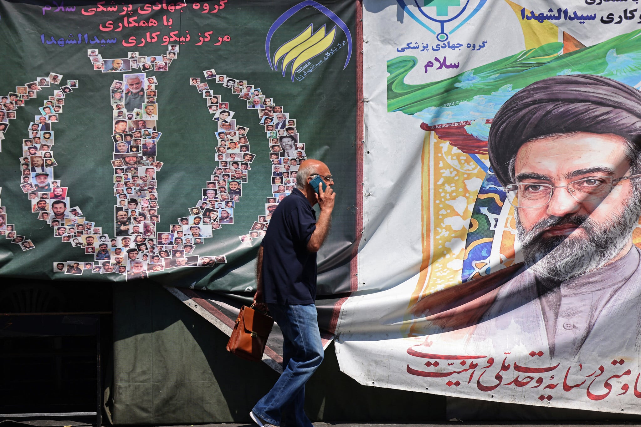 A man walks past a banner of Iran supreme leader Ayatollah Mojtaba Khamenei on a Tehran street during the Iran-Israel war 2026