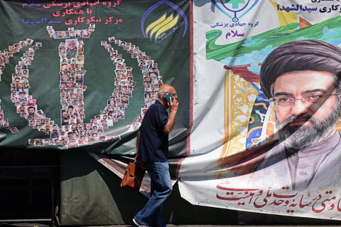 A man walks past a banner of Iran supreme leader Ayatollah Mojtaba Khamenei on a Tehran street during the Iran-Israel war 2026