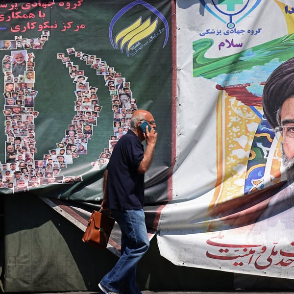 A man walks past a banner of Iran supreme leader Ayatollah Mojtaba Khamenei on a Tehran street during the Iran-Israel war 2026