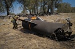 Israeli soldier examines wreckage of an Iranian missile intercepted during the US-Iran war, July 2026