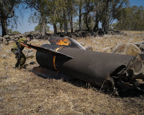 Israeli soldier examines wreckage of an Iranian missile intercepted during the US-Iran war, July 2026