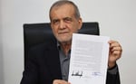 Iran President Masoud Pezeshkian displaying the memorandum of understanding signed to end the 2026 Iran-US war