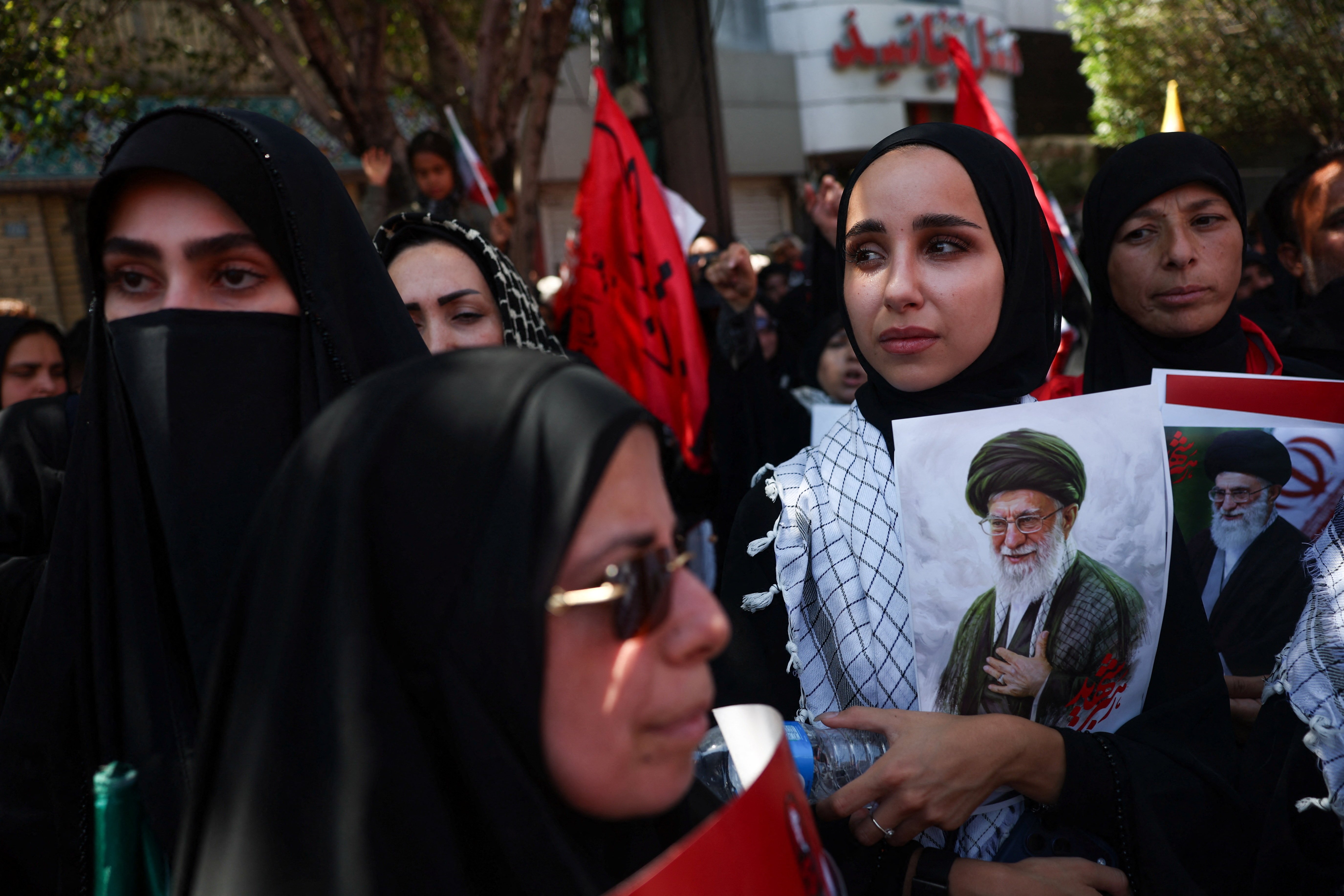 Mourners hold images of Iran's slain Supreme Leader Khamenei on burial day in Mashhad