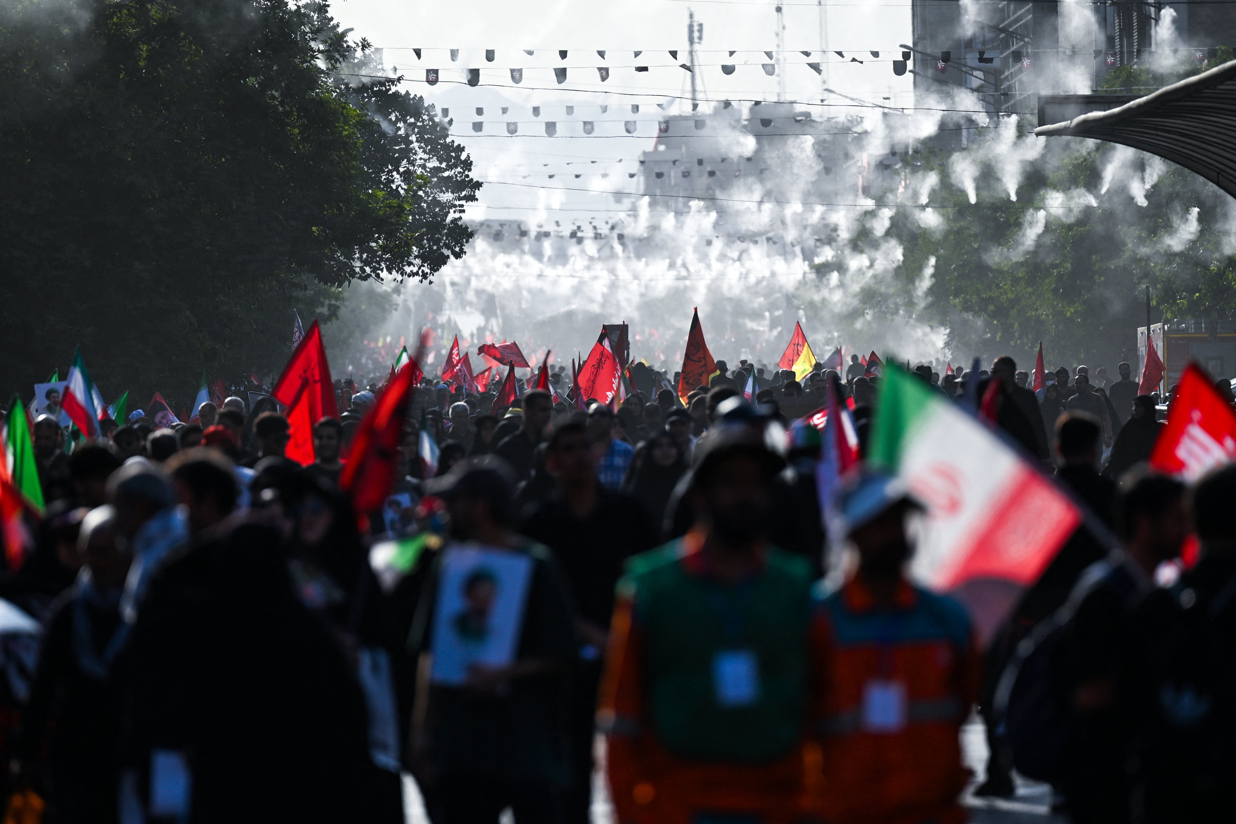 Mourners carry red and black banners during the funeral procession for Ayatollah Ali Khamenei in Tehran, July 6, 2026
