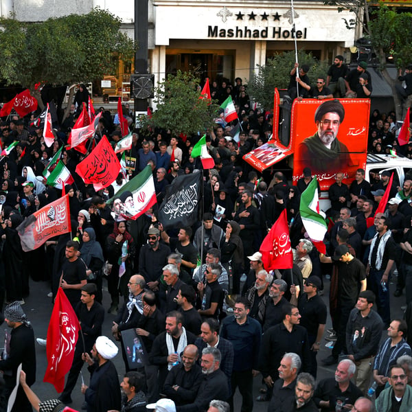 People gather around a portrait of Iran's Supreme Leader Ali Khamenei during a demonstration in Tehran following the collapse of the Islamabad MoU.