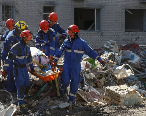 Emergency rescuers recover a victim from debris at a damaged apartment building in Kyiv's Darnytskyi district following Russia's overnight missile and drone attack, July 2, 2026