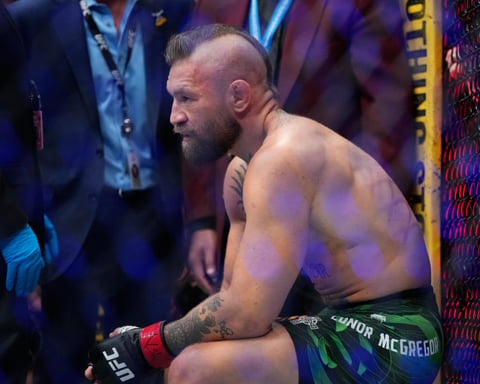 Conor McGregor attempts a kick against Max Holloway at UFC 329 in Las Vegas, resulting in a knee injury that ended the fight in 69 seconds