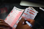 Customer fills out Mega Millions and Powerball lottery tickets at a gas station in California