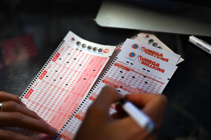 Customer fills out Mega Millions and Powerball lottery tickets at a gas station in California