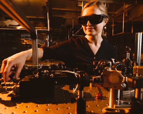 A researcher adjusts instruments on an optics table in a quantum physics laboratory at the National Research Council of Canada