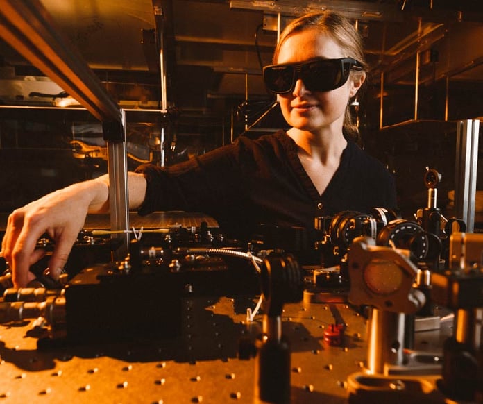 A researcher adjusts instruments on an optics table in a quantum physics laboratory at the National Research Council of Canada