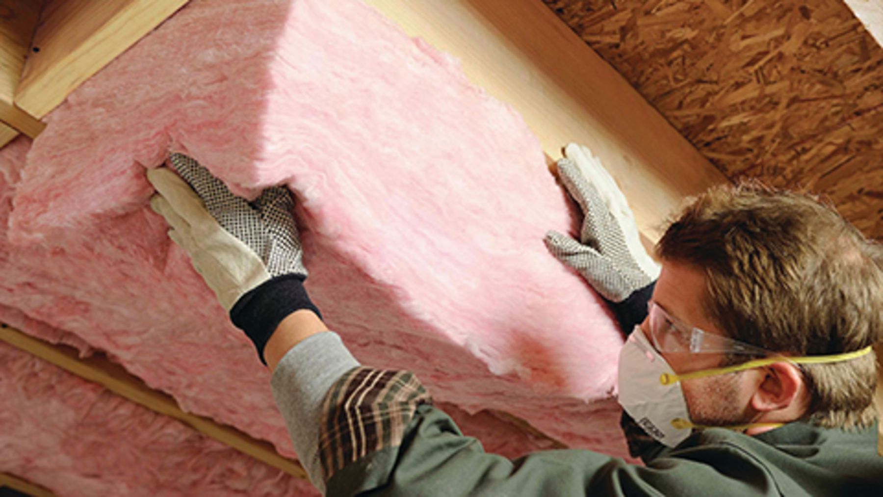 Owens Corning pink fiberglass insulation being installed in a ceiling