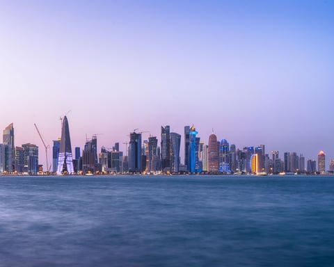 Doha Bay waterfront and West Bay skyline at twilight, Qatar, where Iranian, Qatari, and Pakistani officials held indirect talks on the Islamabad Memorandum of Understanding