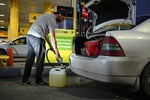 Man filling fuel canister at Omsk gas station amid Russia fuel shortage and odd-even rationing