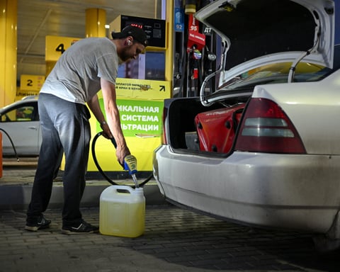Man filling fuel canister at Omsk gas station amid Russia fuel shortage and odd-even rationing