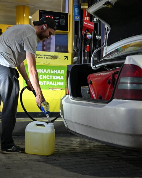 Man filling fuel canister at Omsk gas station amid Russia fuel shortage and odd-even rationing