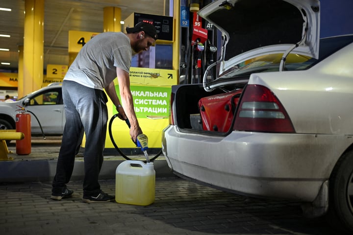 Man filling fuel canister at Omsk gas station amid Russia fuel shortage and odd-even rationing