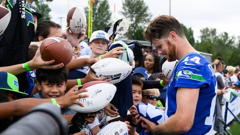 Sam Darnold of the Seattle Seahawks interacts with fans at training camp 2026