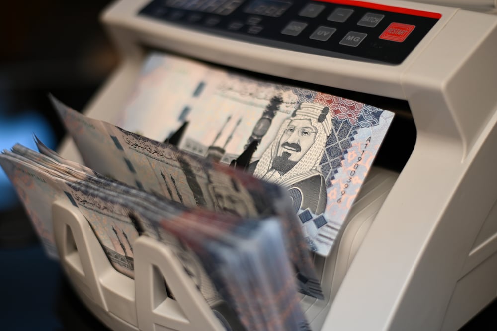 Saudi riyal banknotes on a money counting machine representing Saudi Arabia banking sector growth