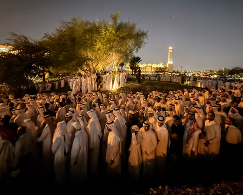 Mourners in traditional Qatari dress attend funeral prayers for Sheikh Hamad bin Khalifa Al Thani at mosque in Doha