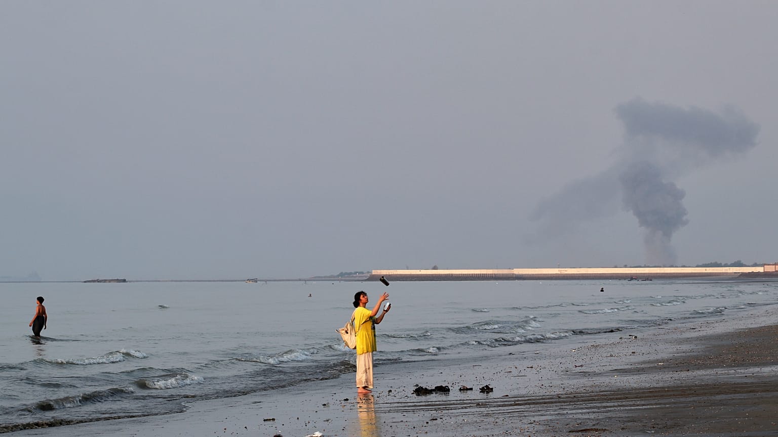 A plume of smoke rises over the Strait of Hormuz following an explosion off Bandar Abbas Iran July 2026