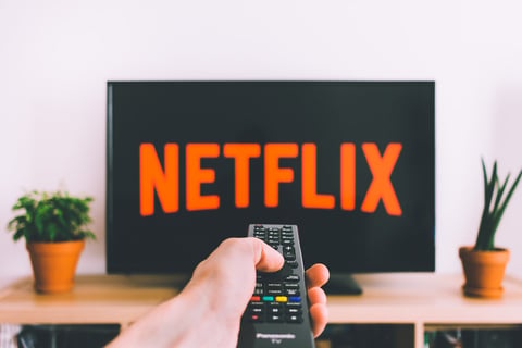 Television streaming service displayed on screen with remote control representing home entertainment