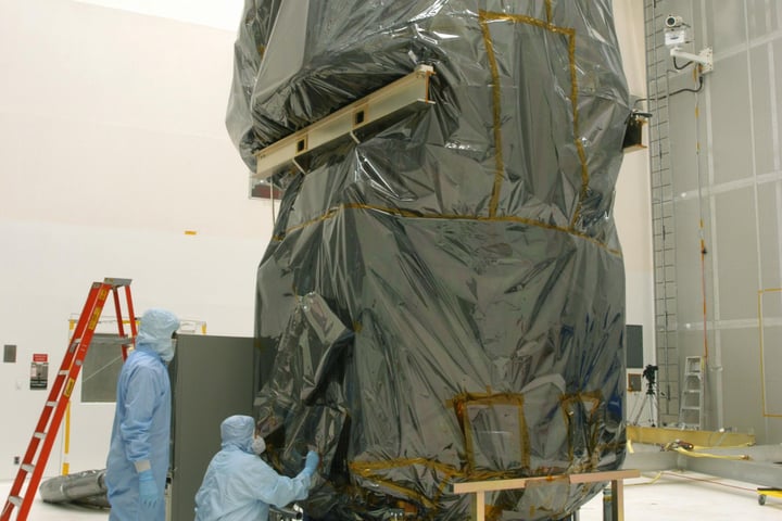 NASA technicians remove protective cover from Swift Observatory solar array at Cape Canaveral in 2004