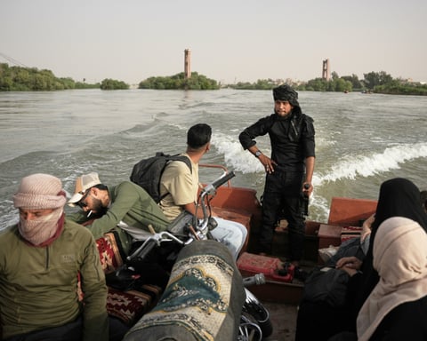 Residents travel by boat along the flooded Euphrates River near Deir Ezzor Syria where a ferry accident killed two children