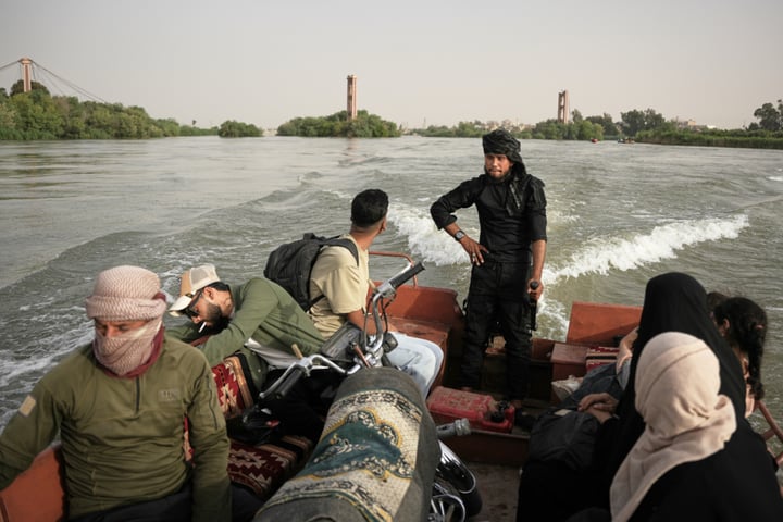 Residents travel by boat along the flooded Euphrates River near Deir Ezzor Syria where a ferry accident killed two children