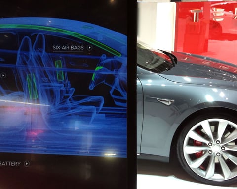 Tesla vehicle cutaway illustration as company imposes $200 per week AI tool spending cap exempting Grok from Elon Musk's xAI