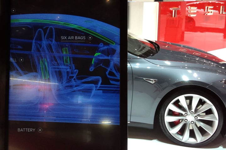 Tesla vehicle cutaway illustration as company imposes $200 per week AI tool spending cap exempting Grok from Elon Musk's xAI