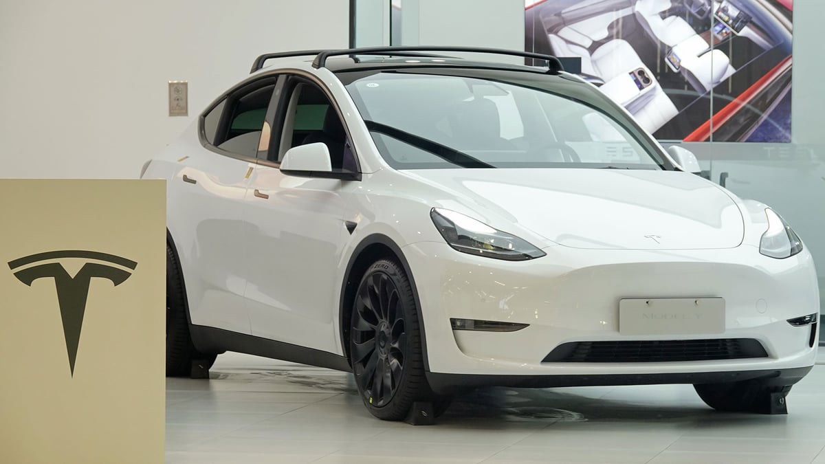A white Tesla vehicle on a road, representing the NTSB and NHTSA investigation into Tesla Full Self-Driving crashes