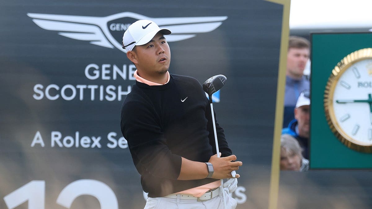 Tom Kim speaks with his caddie on the fairway during the Genesis Scottish Open at The Renaissance Club