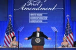 Donald Trump at the White House Correspondents' Dinner holding a Trump 2028 hat