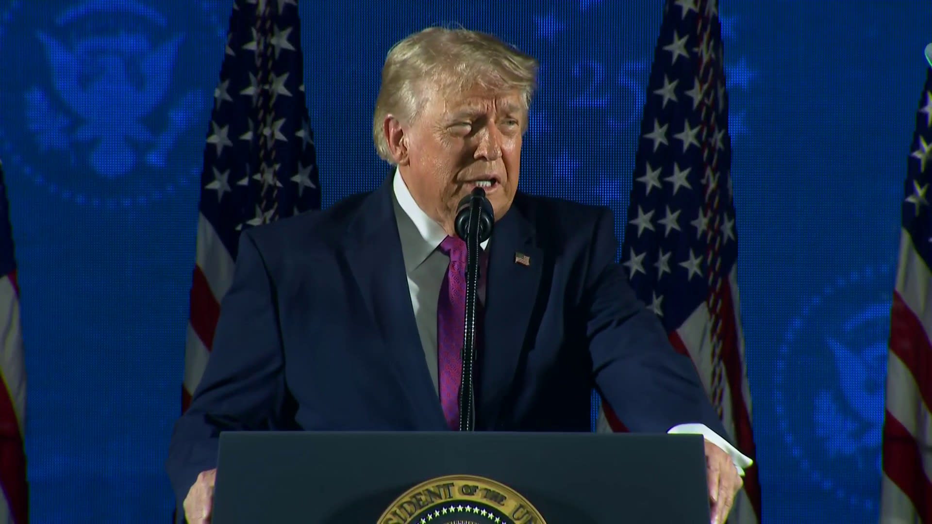 President Trump speaks at podium with Mount Rushmore monument visible behind him during America 250 celebration July 4 2026