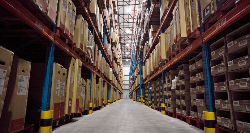 Warehouse shelves with boxes representing UAE import supply chains disrupted by Iran war Hormuz rerouting