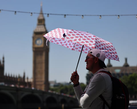 Pedestrian sheltering from extreme heat in London during record-breaking UK heatwave June 2026