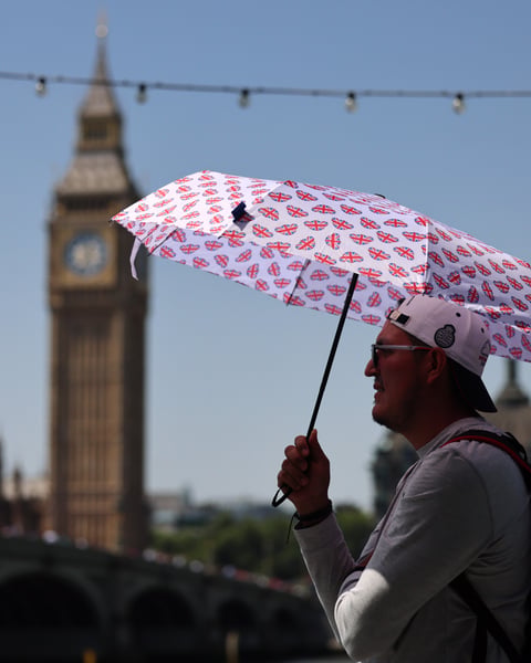 Pedestrian sheltering from extreme heat in London during record-breaking UK heatwave June 2026