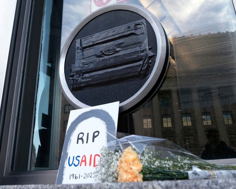 Flowers and signs outside the USAID headquarters in Washington on February 7, 2025, after the Trump administration began dismantling the agency