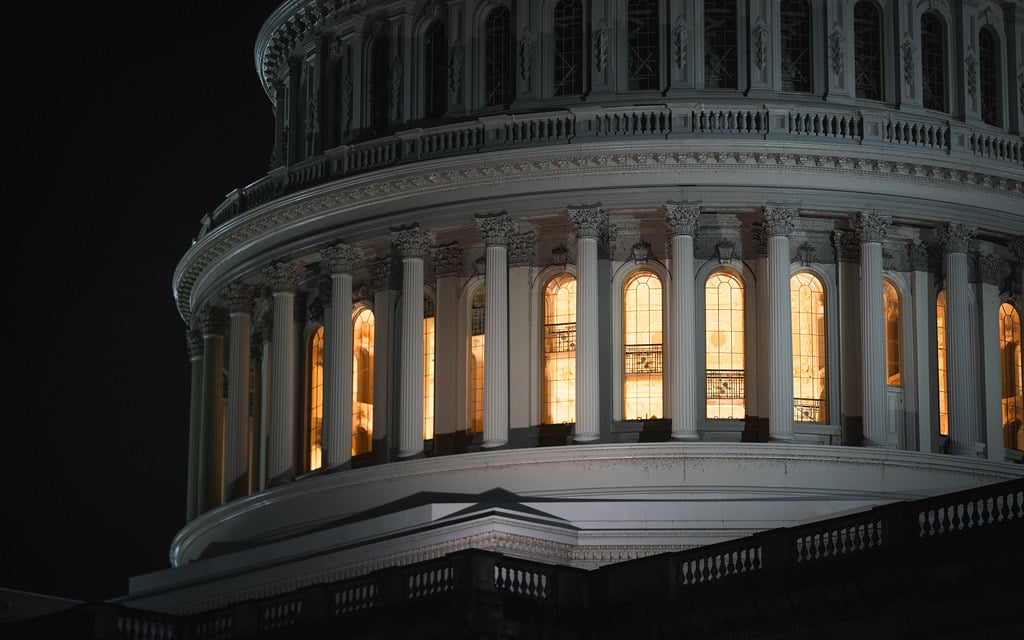 Close-up of the US Capitol building dome at night with lit interior windows