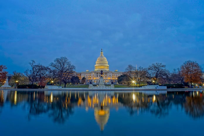 United States Capitol building illuminated at night reflected in the Capitol Reflecting Pool