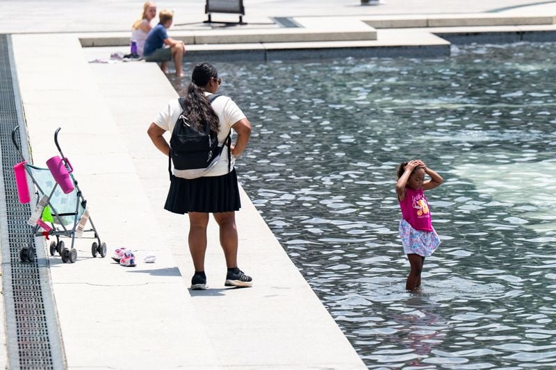 A child cools off in the water at the National World War II Memorial in Washington during the extreme heat wave July 2026