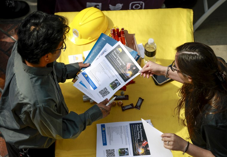 Job seekers browse booths at a career fair in Carson California as US June jobs report shows 57000 payroll gains