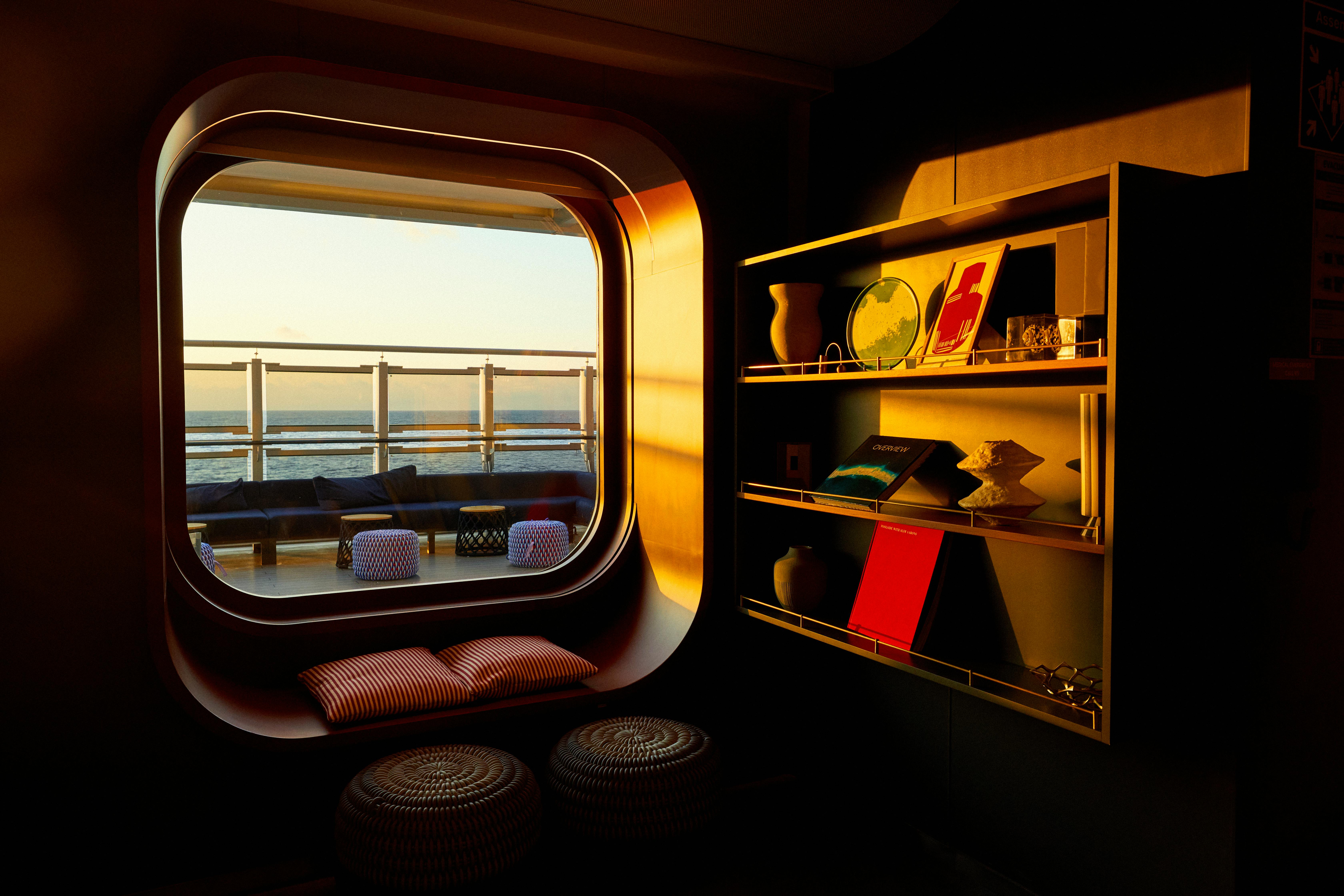 Interior of Virgin Voyages Scarlet Lady cruise ship with porthole ocean view, chartered by Atlantis Events for LGBTQ Athens-to-Venice voyage
