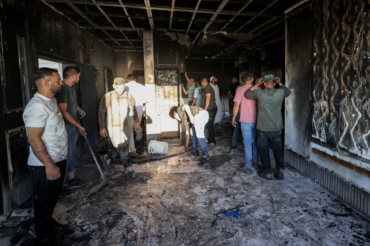 Palestinians watch smoke rise near the village of Tell west of Nablus in the occupied West Bank after an arson attack by Israeli settlers July 2026